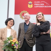 Die 3 lächelnden Gewinner:innen im Gruppenfoto bei der Verleihung vom Preis der Leipziger Buchmesse 2024